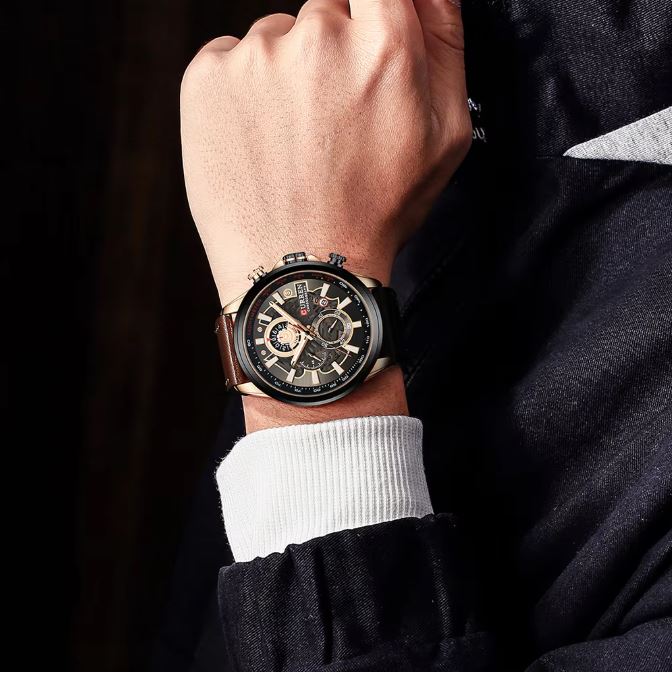 Close-up of a wrist wearing a detailed wristwatch with a dark background