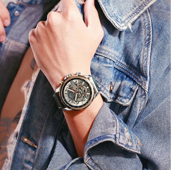Hand wearing a watch with a denim jacket