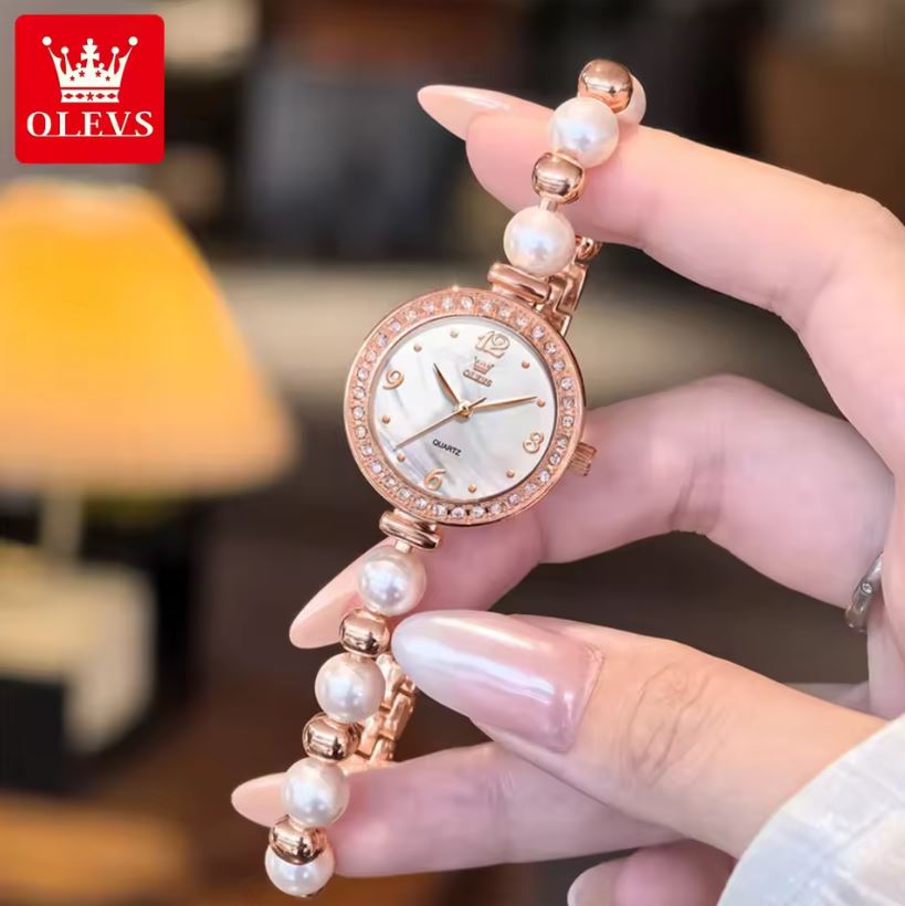 Hand holding a pearl-wrapped watch with OLEVS branding in the corner.