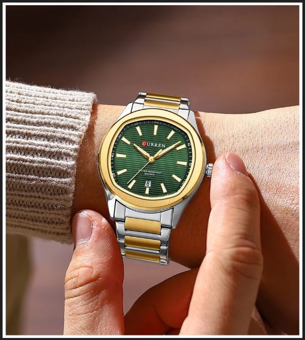 Green watch with gold accents on a wrist, brand 'Curren' visible