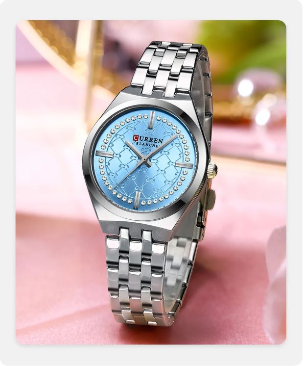 Silver watch with a blue face on a pink fabric background
