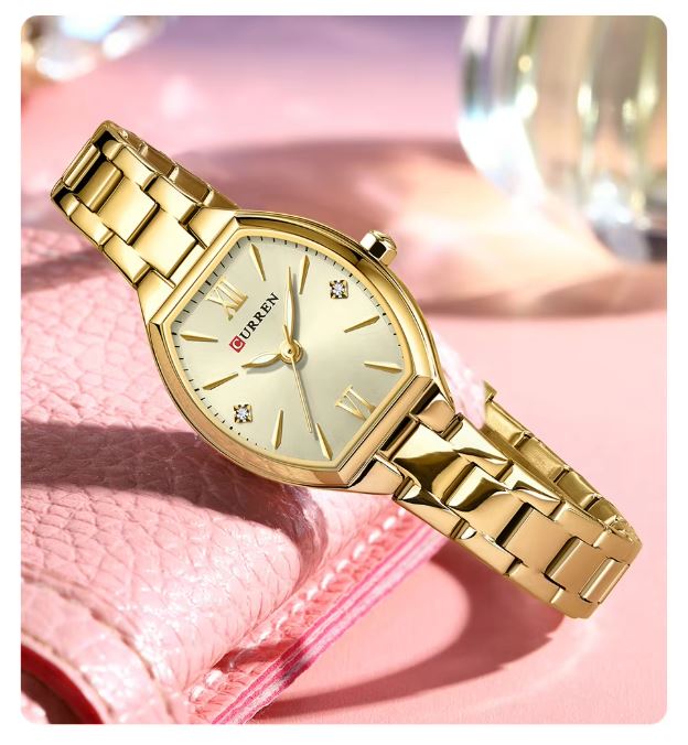 Gold wristwatch with a pink background
