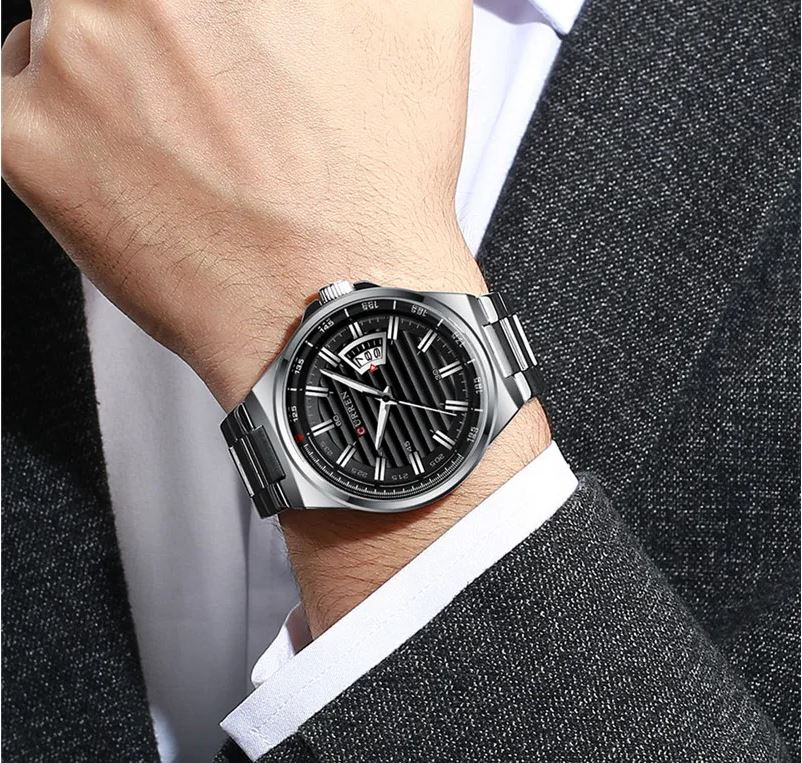 Silver watch on a person's wrist with a suit background