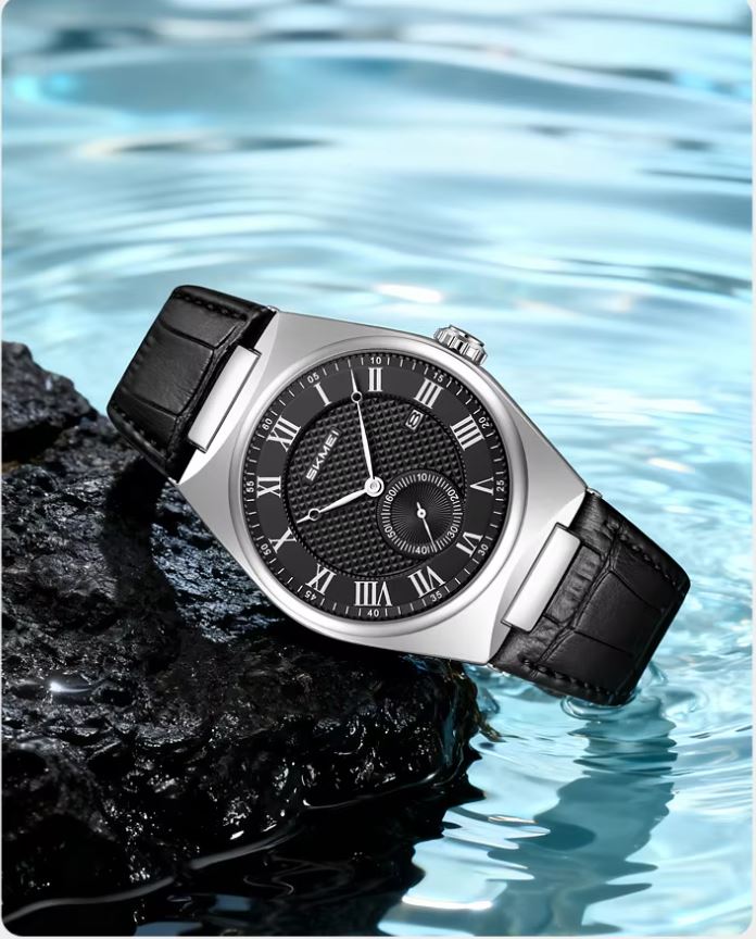 Watch with black leather strap and black dial on a rock with water background