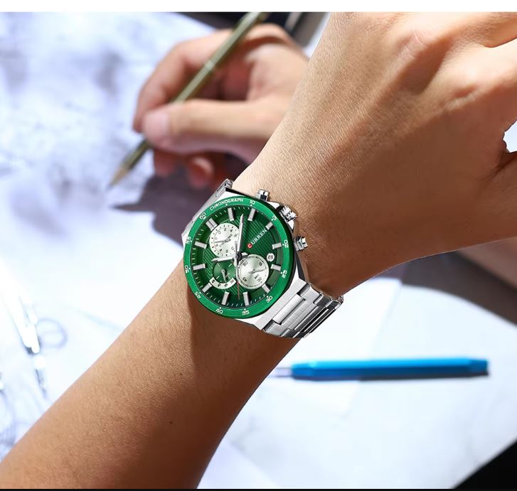 Close-up of a wrist wearing a green watch with a blurred background