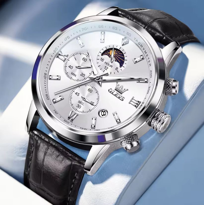 Luxury watch with black leather strap and silver case on a light blue background