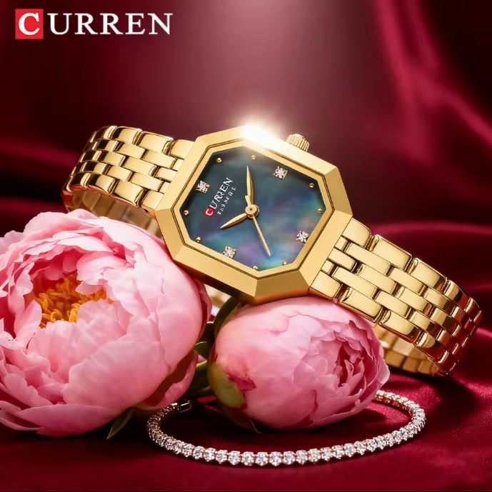 Gold wristwatch with a green face on pink flowers against a red background, featuring the brand 'Curren'.