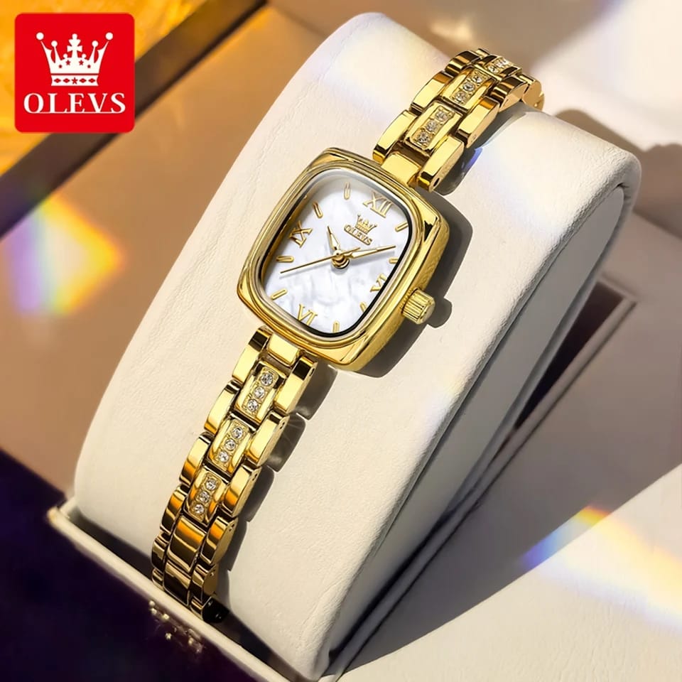 Gold wristwatch with a white face in a box, branded OLEVS.