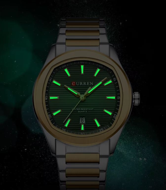 Watch with green glowing face on a dark background