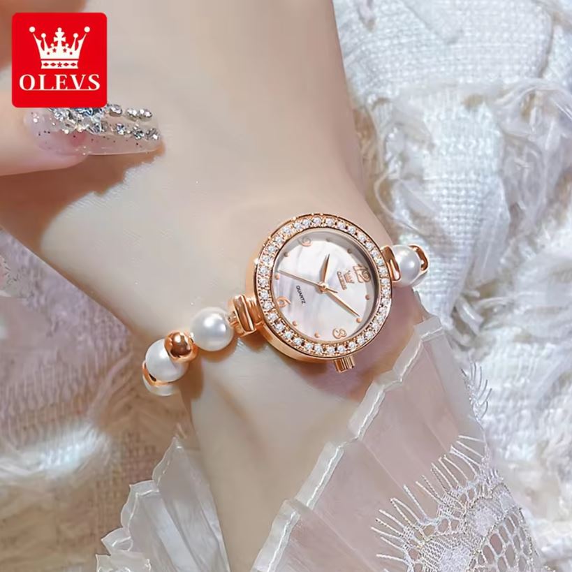 Rose gold watch with pearl accents on a mannequin wrist, brand 'OLEVS' visible.
