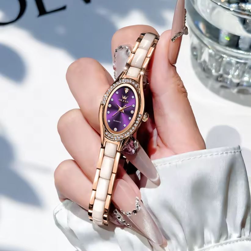 Hand holding a Gucci watch with a purple face and rose gold band.