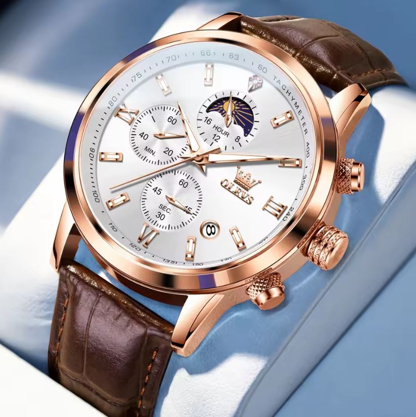 Luxury watch with brown leather strap and rose gold casing on a light blue background