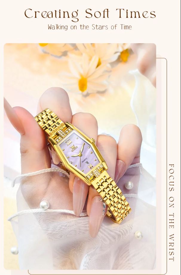Gold wristwatch held by a hand with a soft, blurred background
