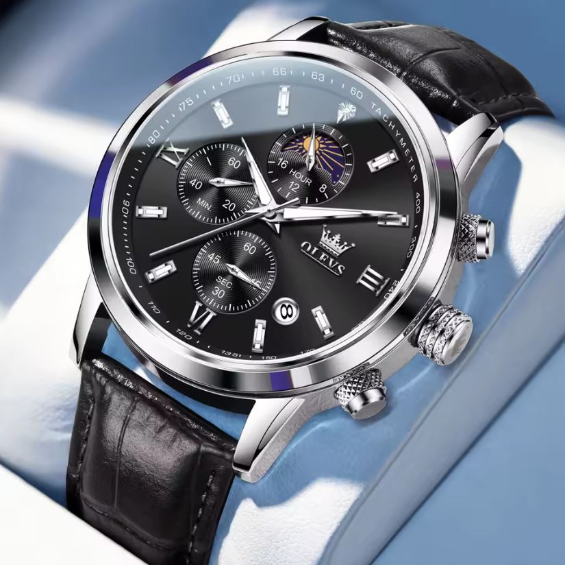 Luxury watch with black leather strap and detailed face on a light blue background