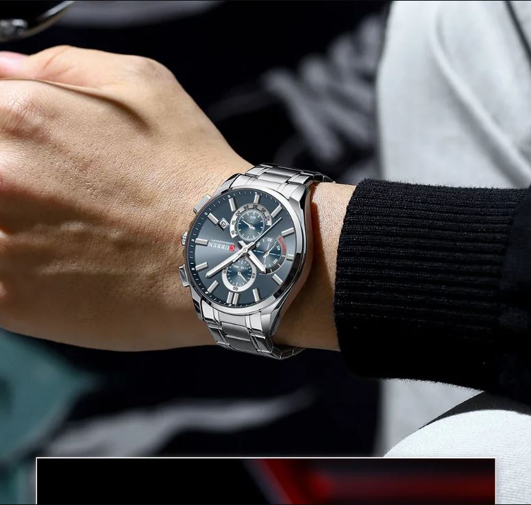 Close-up of a wrist wearing a silver watch with a detailed face.