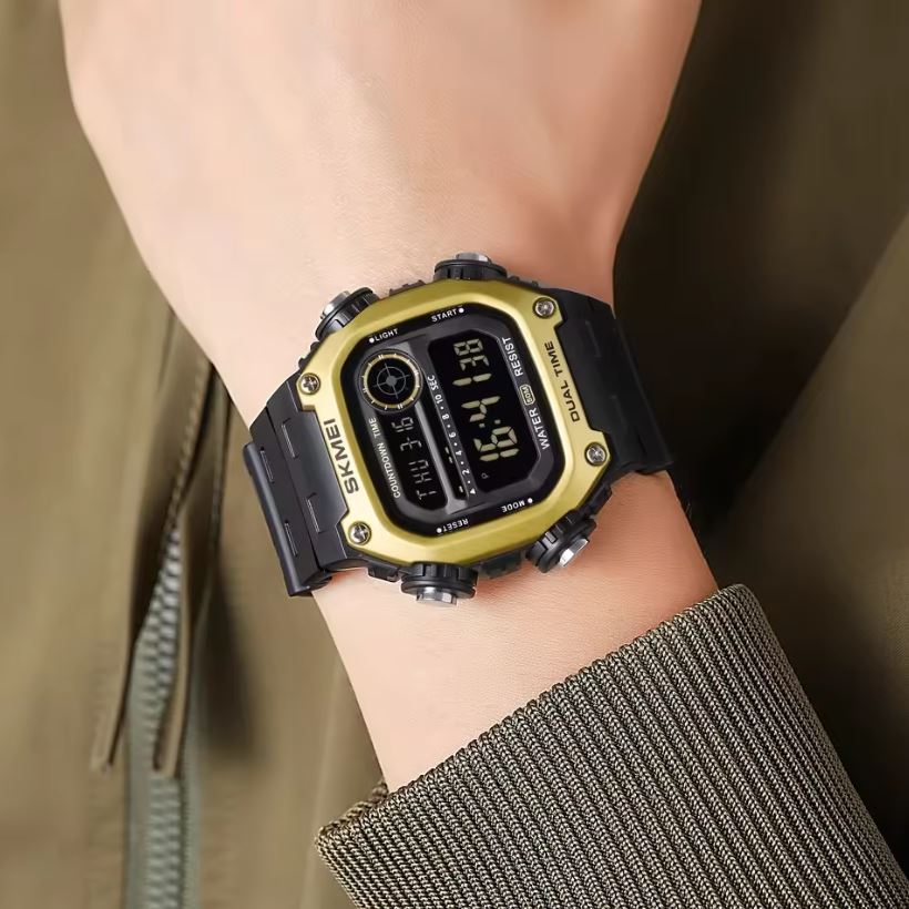Gold and black digital watch on a wrist with a blurred background