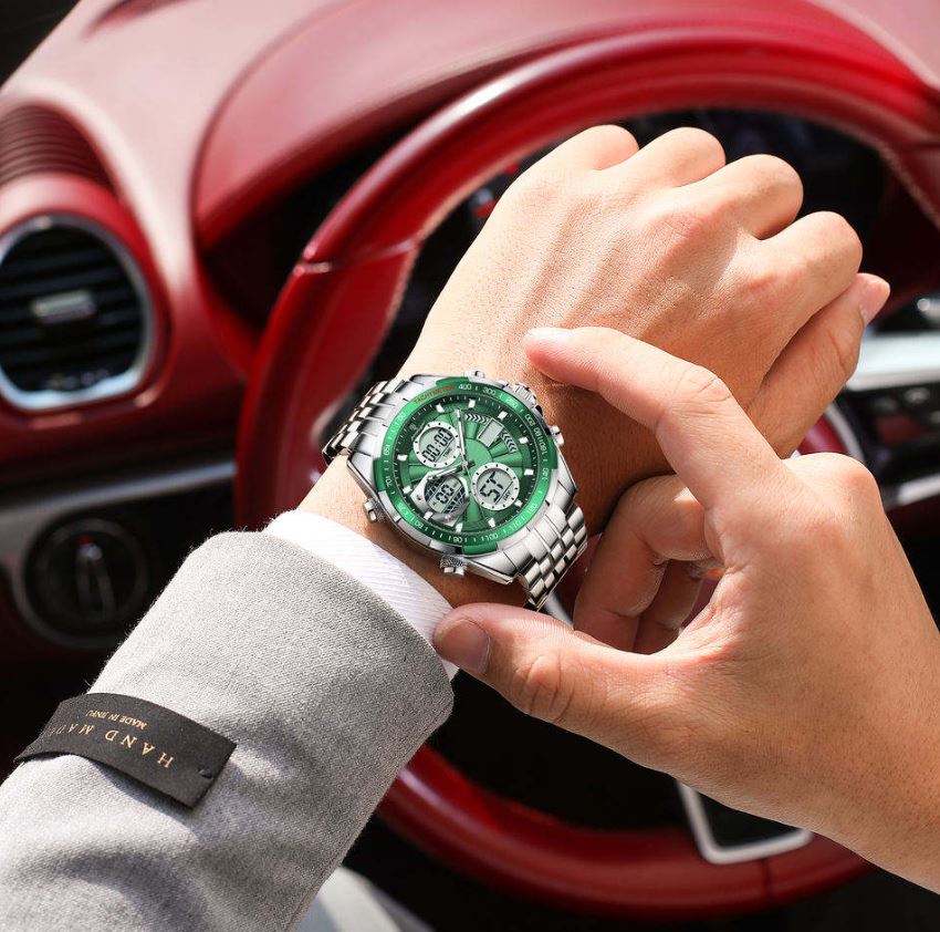 Person adjusting a green wristwatch with a red car interior in the background