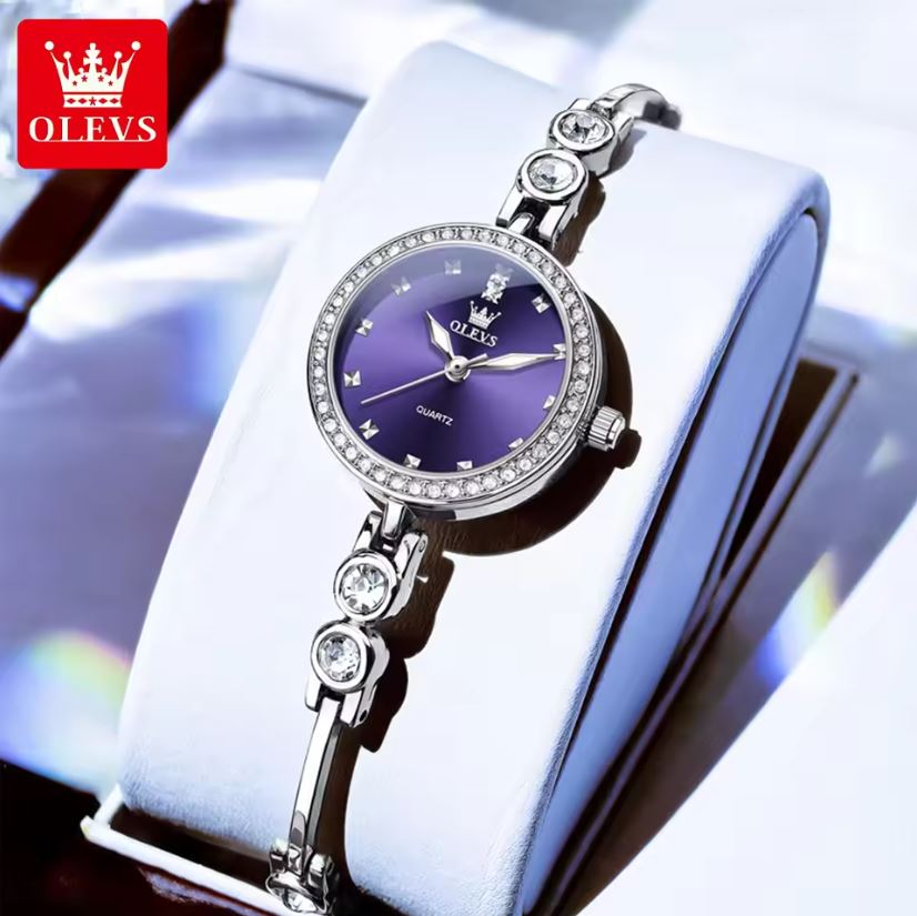 Silver watch with purple face on a white box, OLEVS brand visible