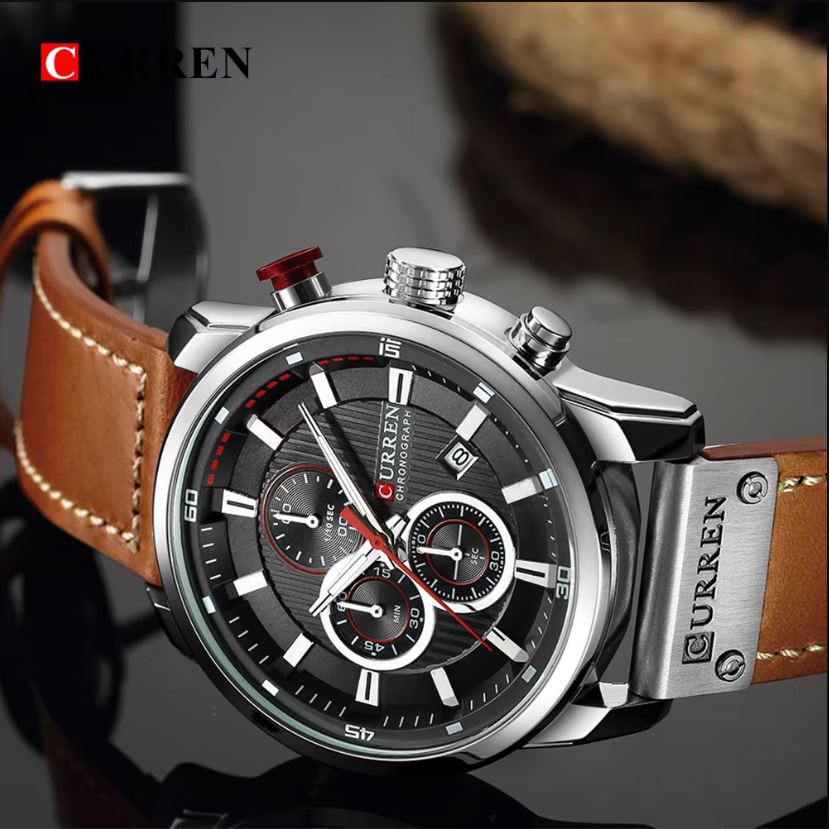 Curren watch with brown leather strap and black dial on a reflective surface