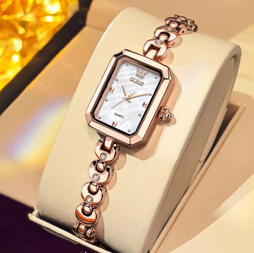 Rose gold watch with diamond accents on a white box