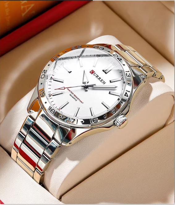 Silver and gold watch with white face on a beige surface