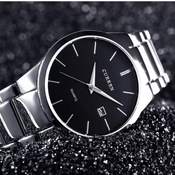 Silver watch with black face on a dark textured background