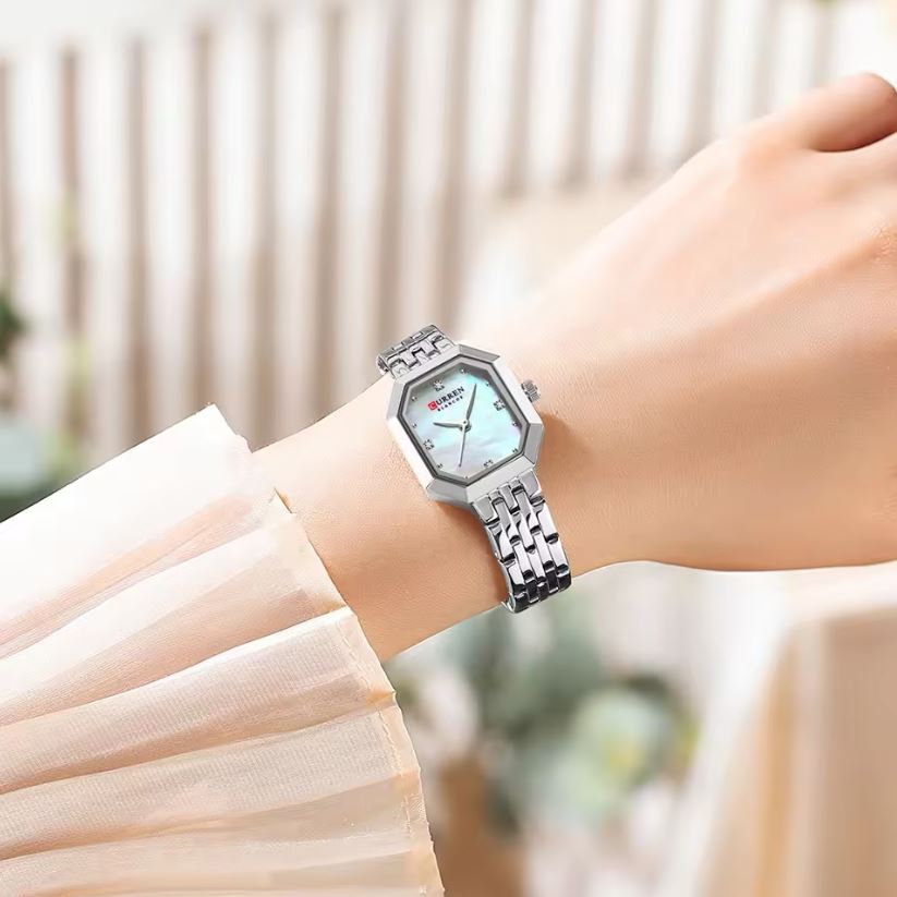 Silver watch on a wrist with a blurred background