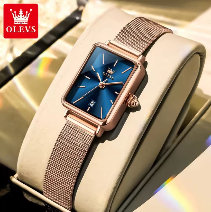 Rose gold watch with blue face on a white cushion, OLEVS brand visible