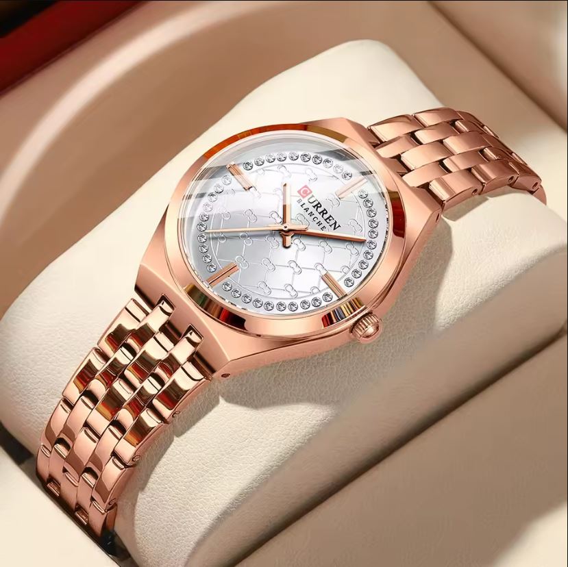 Rose gold watch with a detailed face on a beige cushion