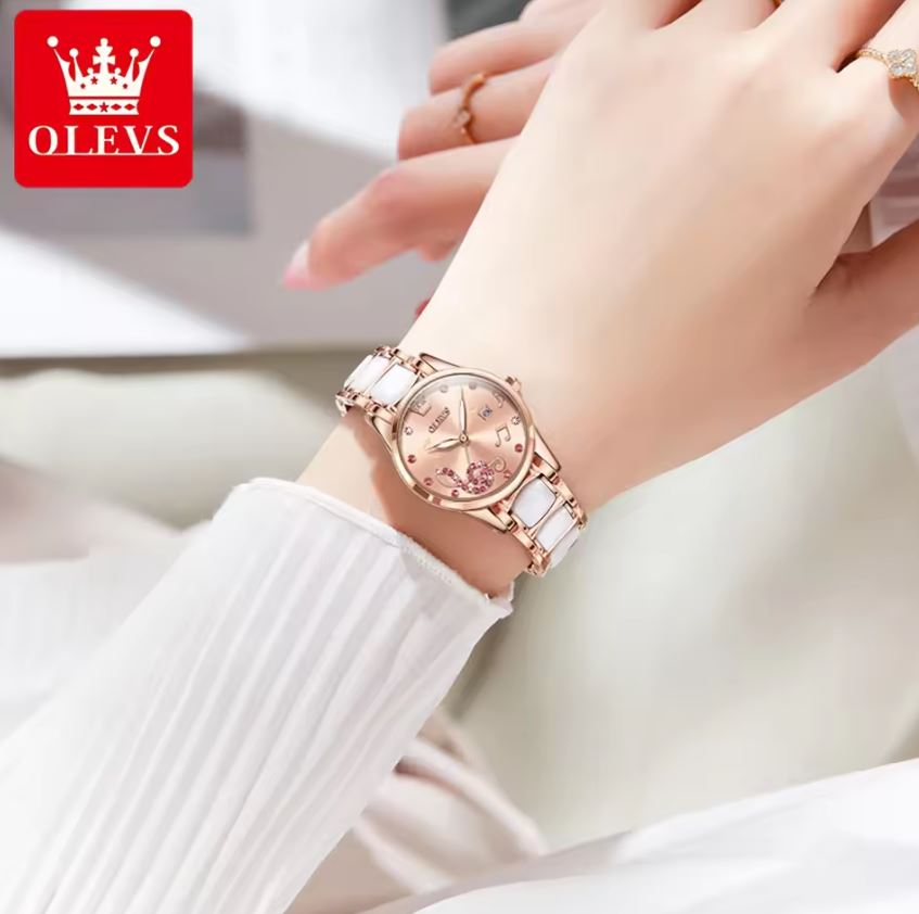 Rose gold watch on a wrist with OLEVS logo in the corner