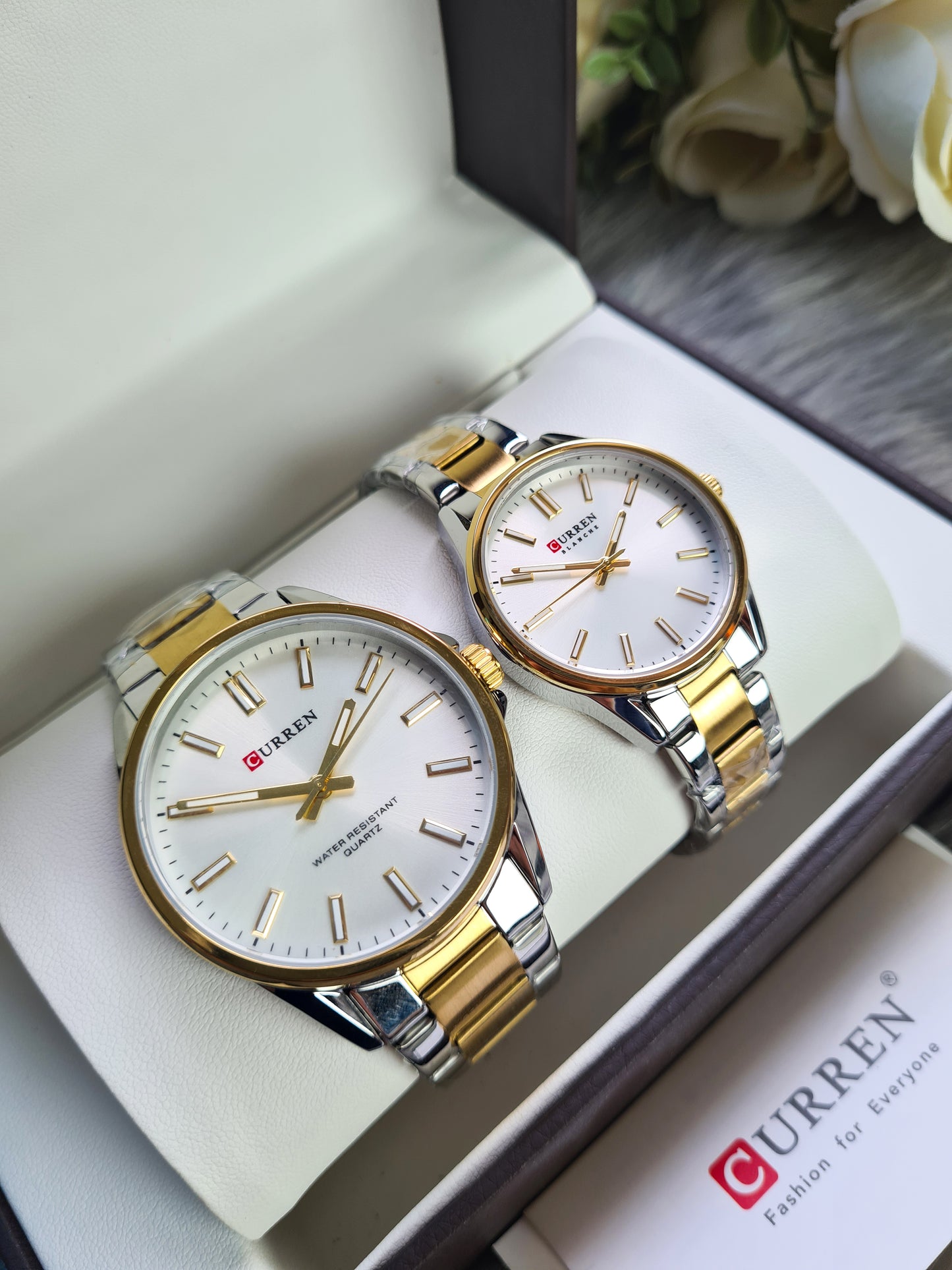 Two gold and silver watches in a box with Curren branding.