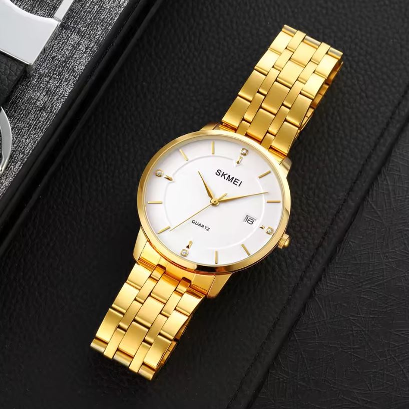 Gold wristwatch with white dial on a black textured background