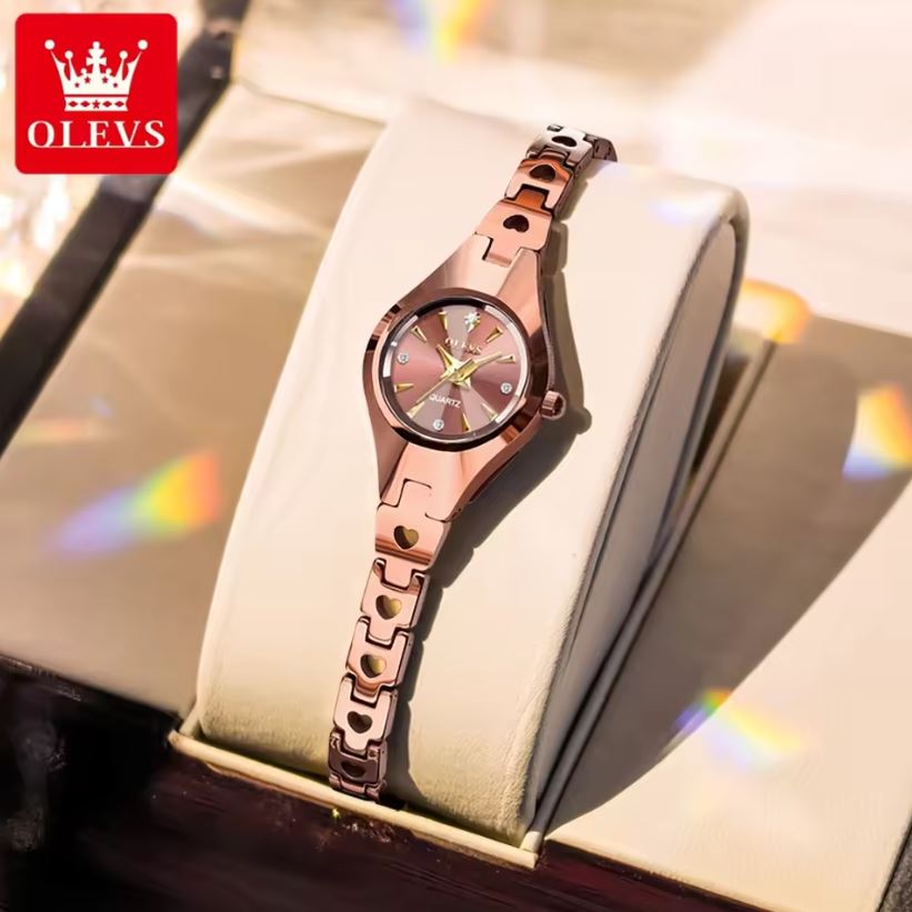 Rose gold watch on a white cushion with OLEVS branding in the corner.