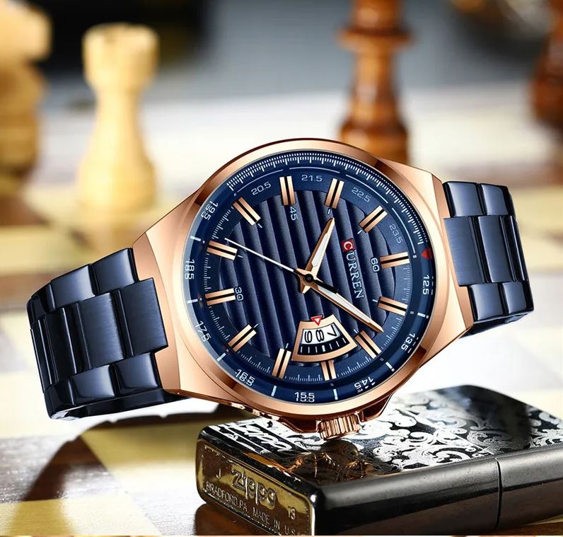 Luxury watch with blue strap and rose gold case on a decorative stand