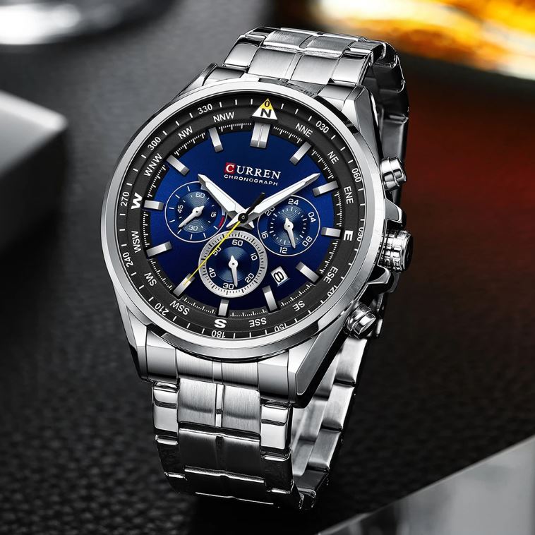 Curren watch with blue face and silver metal strap on a dark textured surface