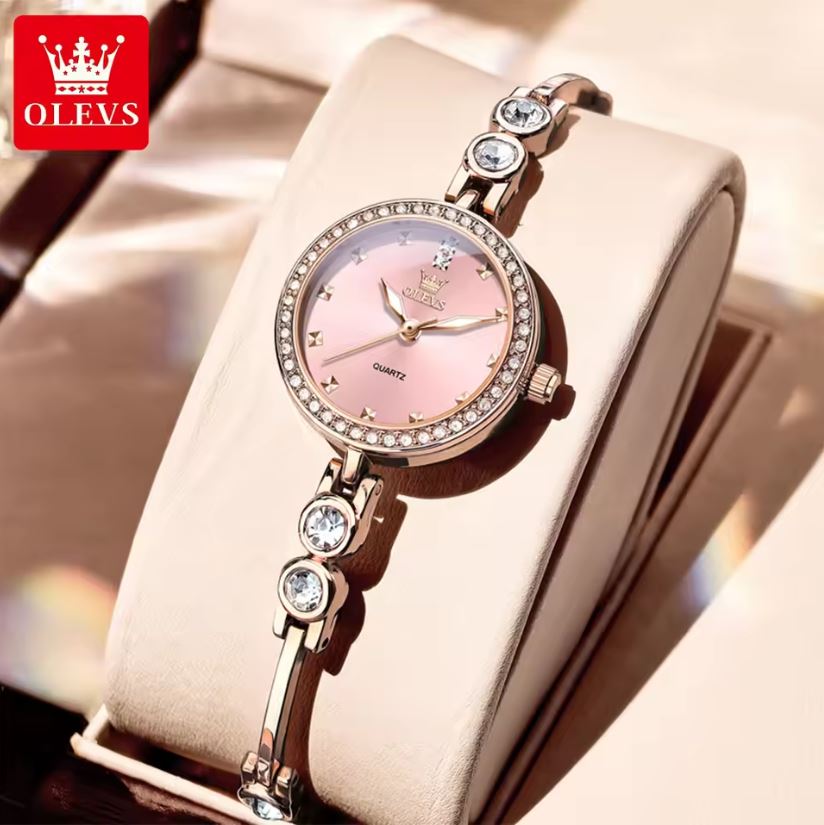 Luxury watch with pink face and rose gold case on a beige background, featuring OLEVS brand logo.