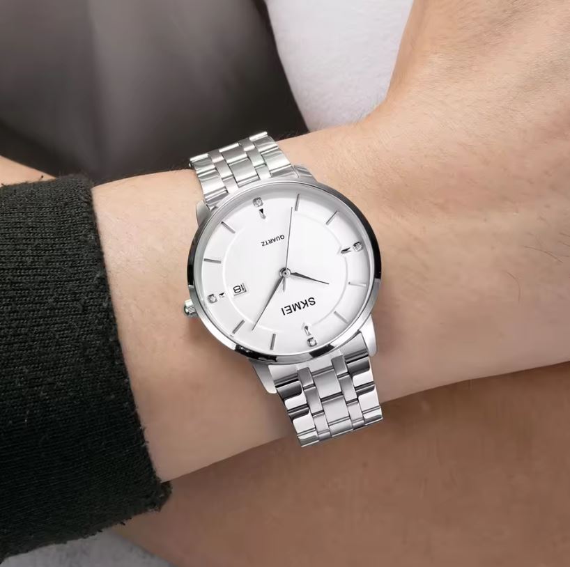 Silver wristwatch with a white dial on a person's wrist