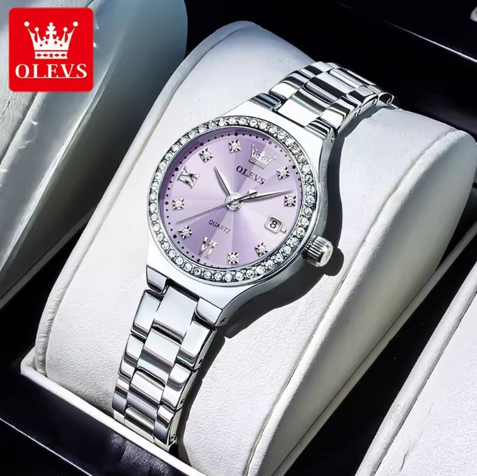Silver watch with purple face and diamond accents on a white cushion, brand 'OLEVS' visible.