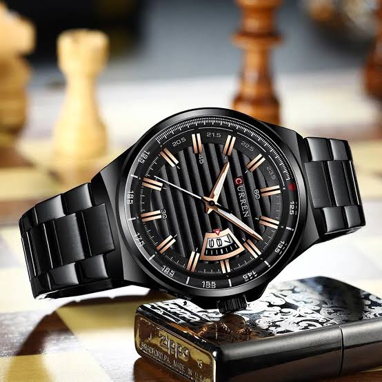 Black wristwatch with detailed face on a chessboard background