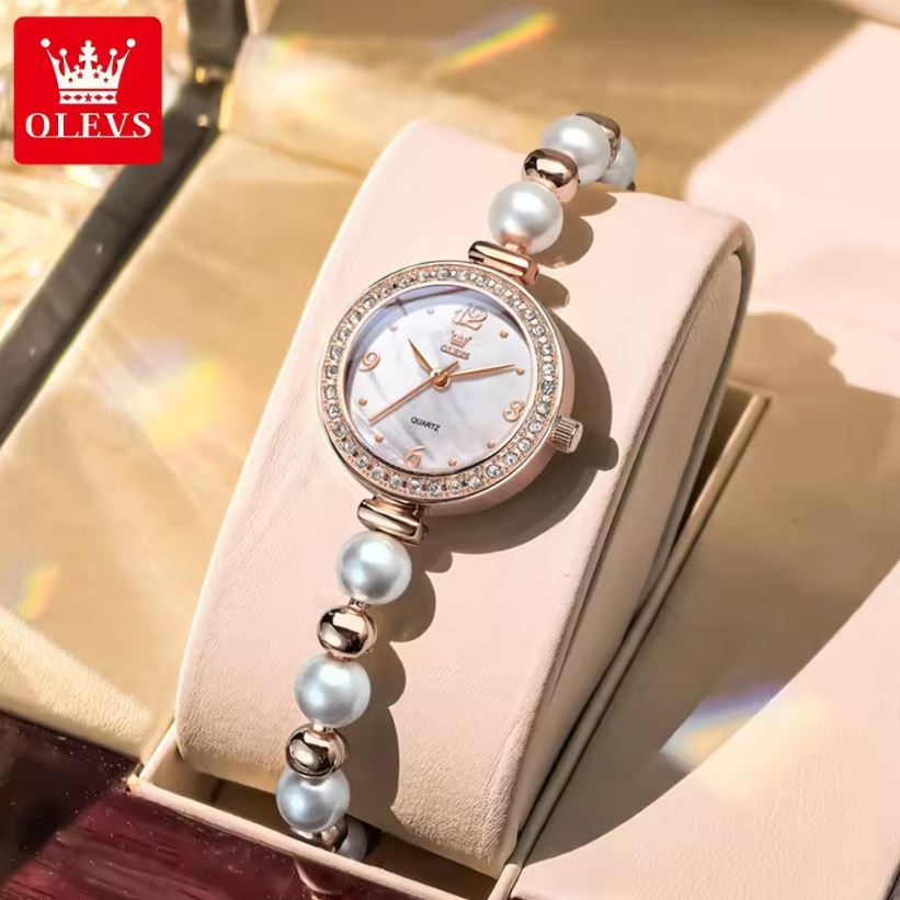 Watch with pearl-like beads on a beige background, featuring the OLEVS brand.