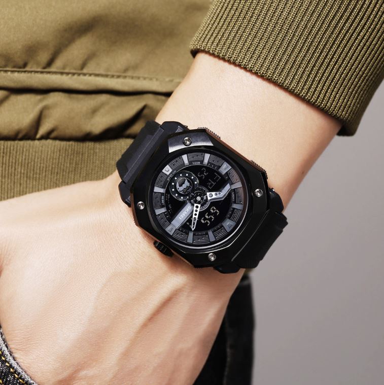 Black wristwatch on a person's wrist with a blurred background