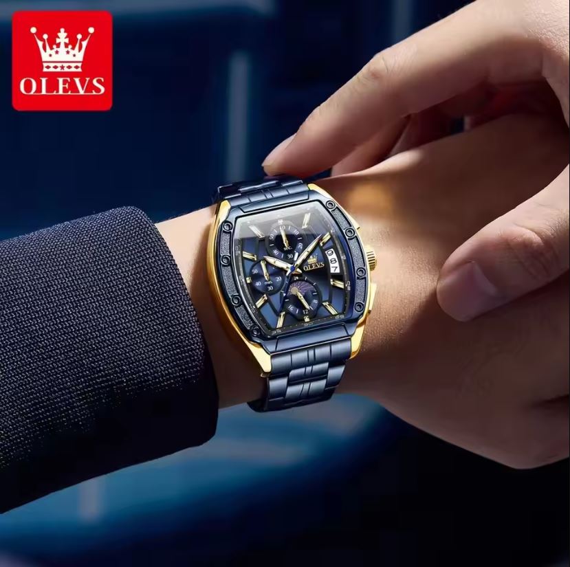 Person wearing a luxury watch with OLEVS branding on a dark background