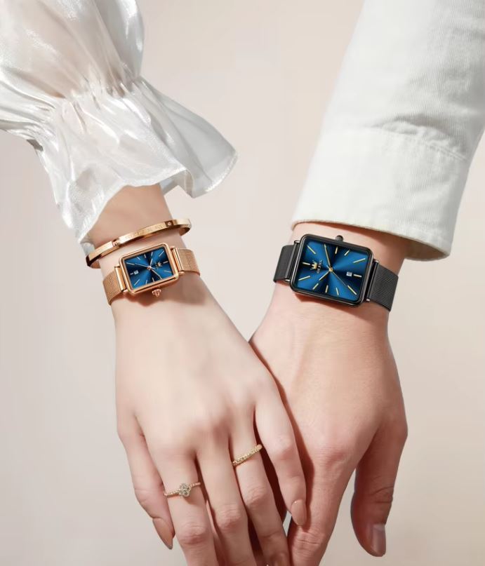 Two hands wearing watches with blue faces on a plain background