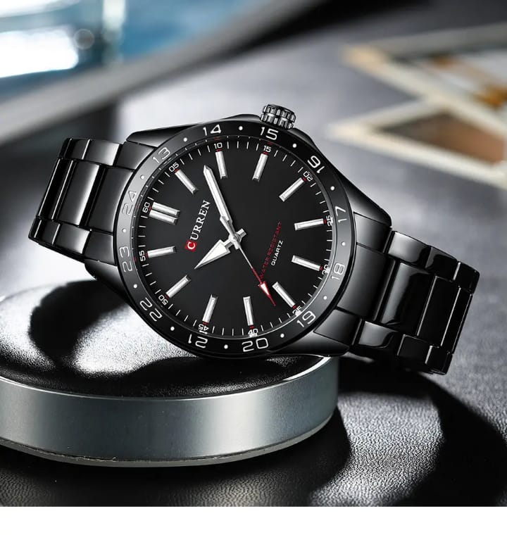 Black wristwatch with a detailed face on a reflective surface