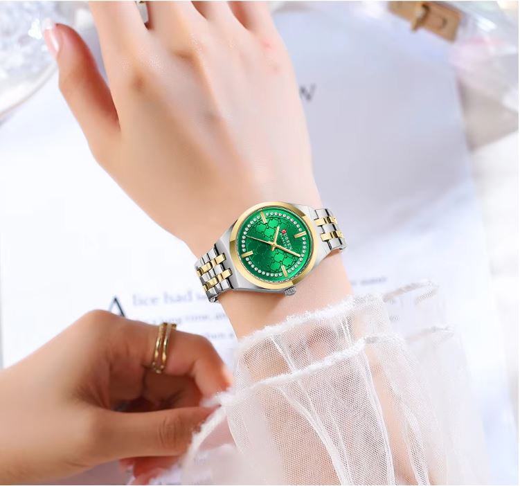 Green wristwatch on a person's wrist with a white background