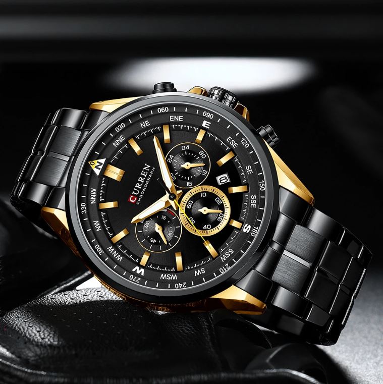 Black and gold watch with detailed face on a dark background