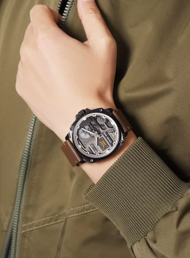 Hand wearing a detailed wristwatch with a brown leather strap on a green jacket background