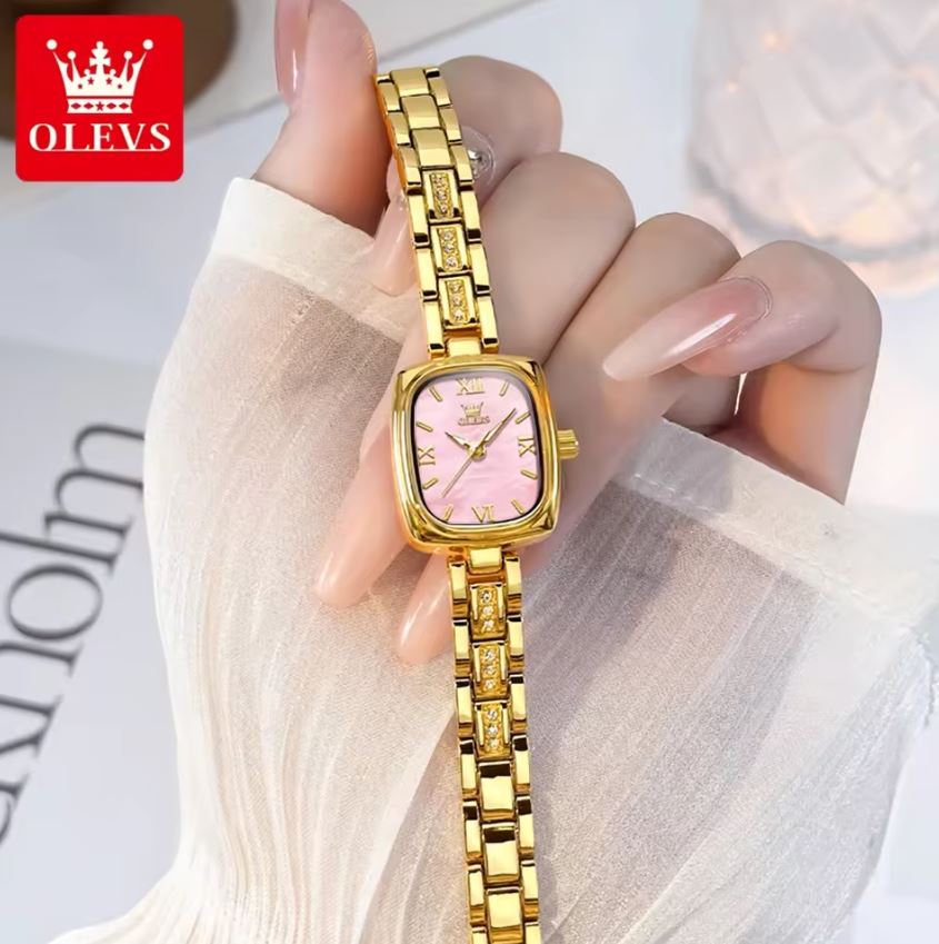 Gold wristwatch with pink face held by a hand, OLEVS brand visible