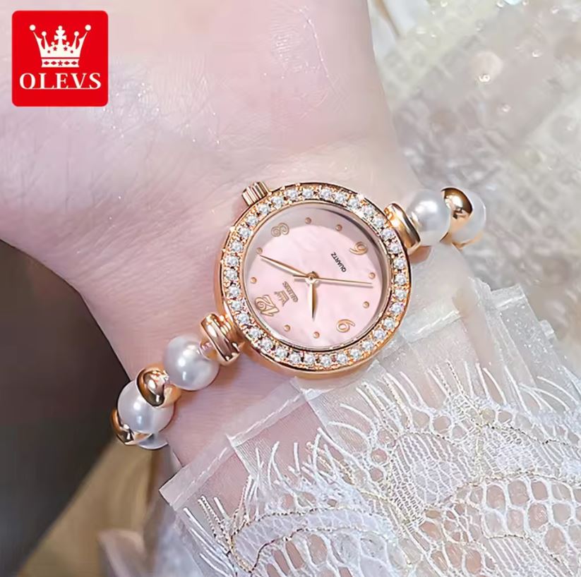 Rose gold watch with pearl bracelet on a lace fabric background, featuring the OLEVS brand.