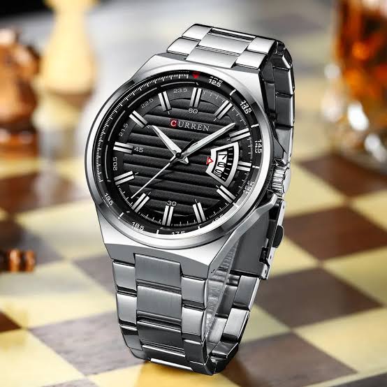 Silver wristwatch with black dial on a checkered background